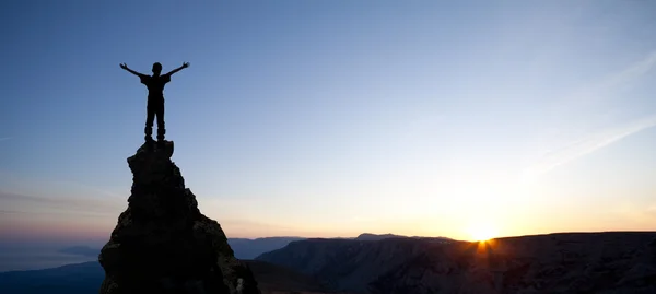 L'uomo in cima alla montagna raggiunge il sole — Foto Stock