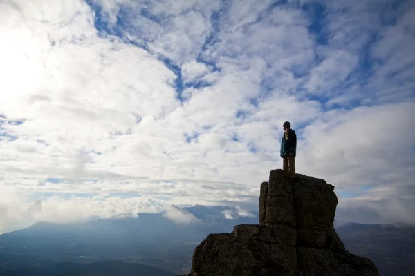 Kvinna på toppen av berget når för solen — Stockfoto
