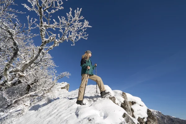 Kvinna på toppen av klippan i vinter berg — Stockfoto