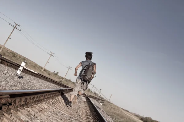 Мальчик-подросток с проблемами, убегающий по железной дороге — стоковое фото