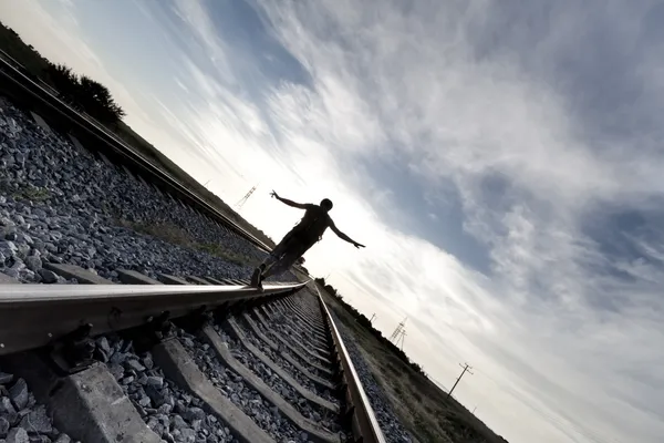Silhouette of man walking on rail road — Stock Photo, Image
