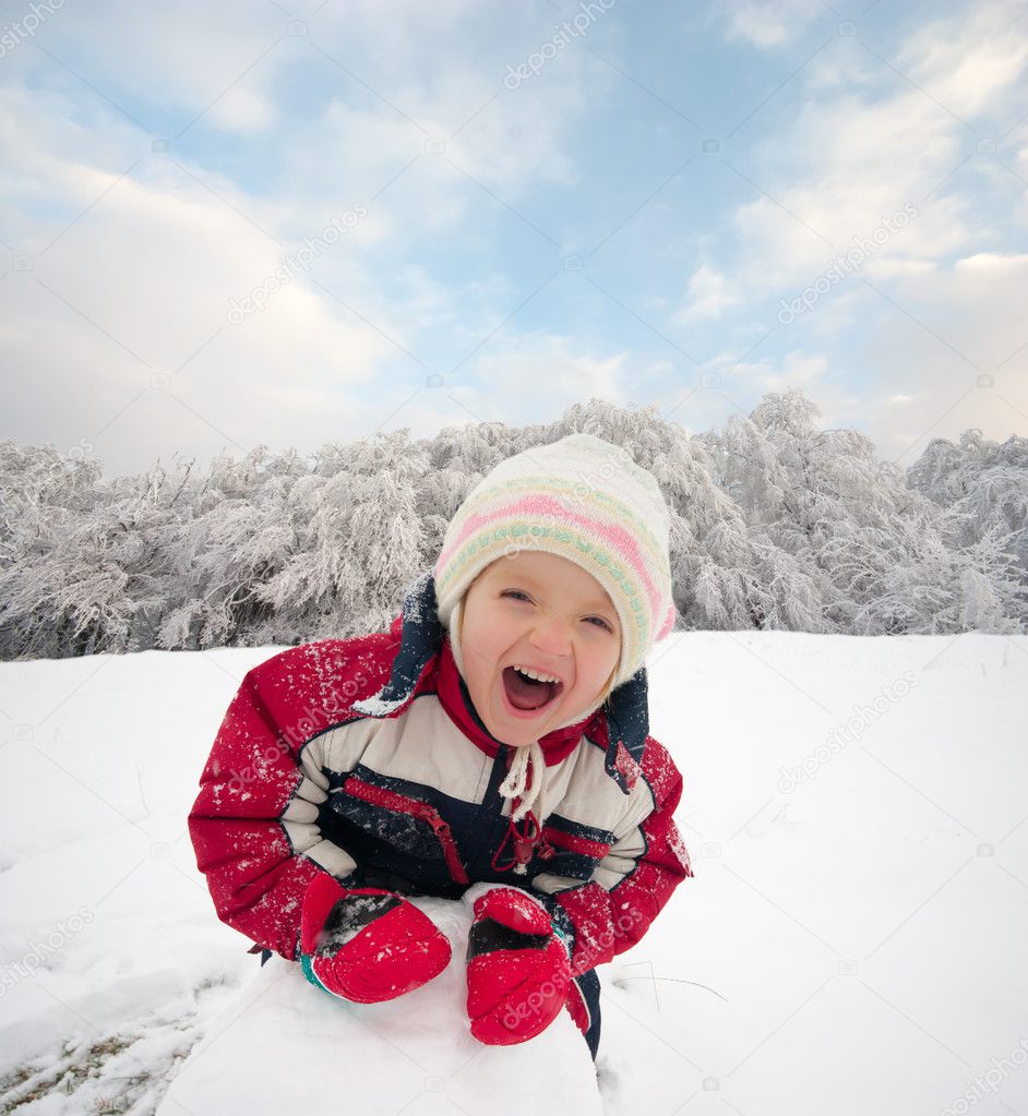Happy little kid is playing in snow, good winter weather