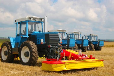 Group of powerful tractors on the field clipart