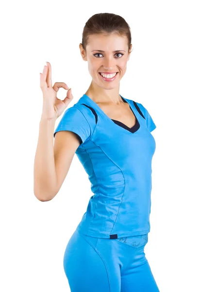 Girl in a blue sports suit shows ok — Stock Photo, Image