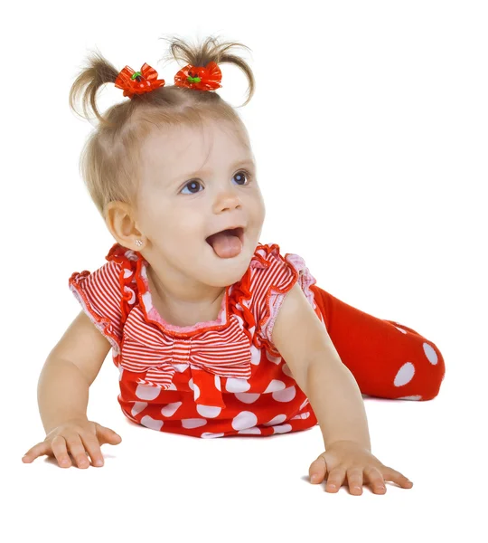 Ein kleines Kind im roten Kleid zeigt Zunge — Stockfoto