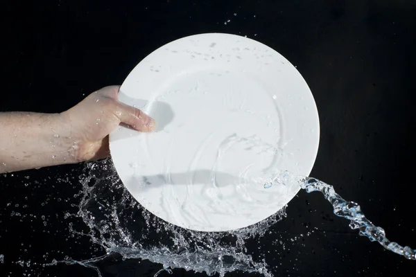 Fröccsenő víz egy tányér — Stock Fotó