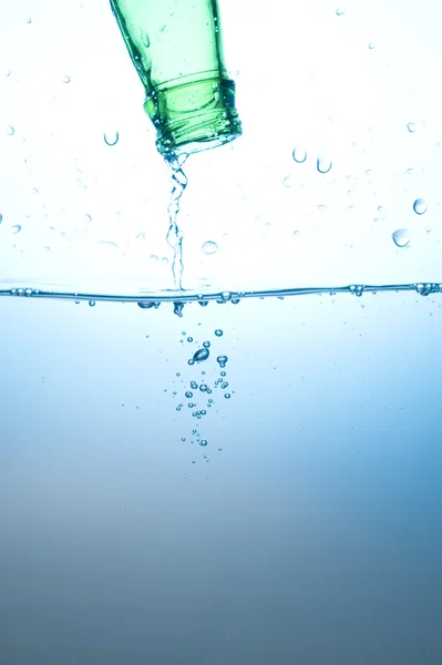 Zöld üveg, és fröccsenő víz — Stock Fotó