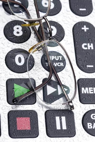 Remote control and glasses — Stock Photo, Image