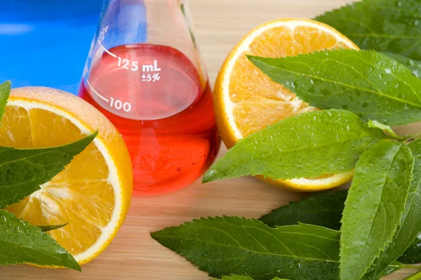 Frasco de laboratorio y naranja — Foto de Stock