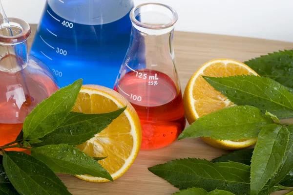 Frasco de laboratorio y naranja — Foto de Stock
