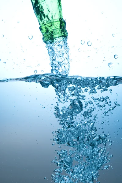 Groene fles en waterspatten — Stockfoto