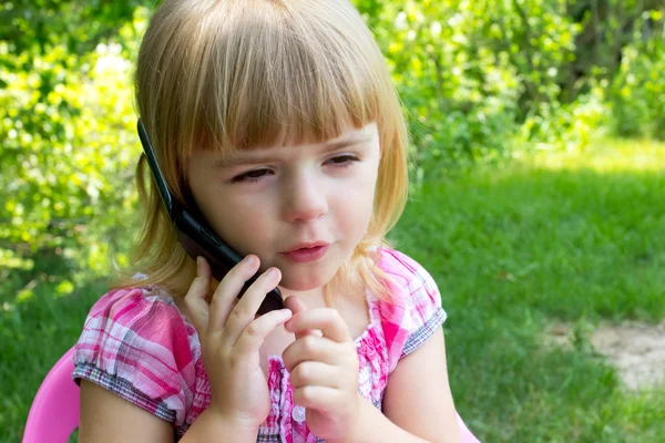 Liten flicka pratar i telefon — Stockfoto