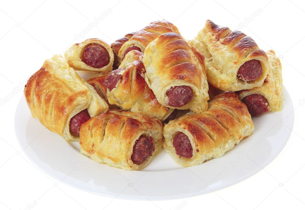 Sausage rolls on a plate, isolated on white