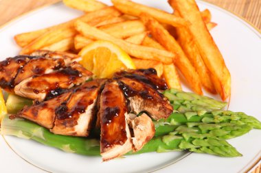 Chicken breasts with asparagus and sauce clipart
