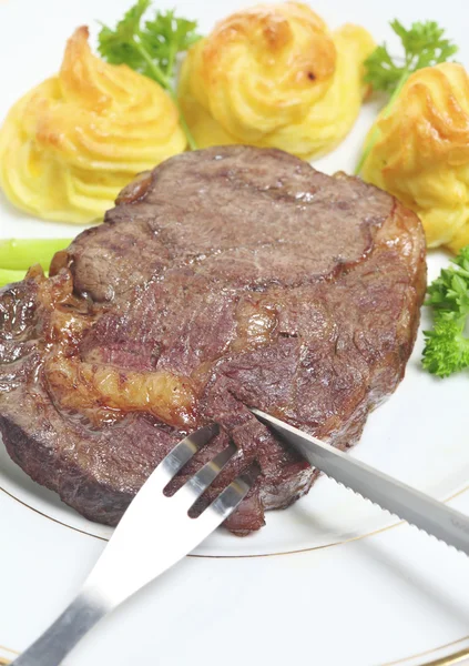 Étkezés a steak, spárga és duchesse burgonyával a tányéron — Stock Fotó