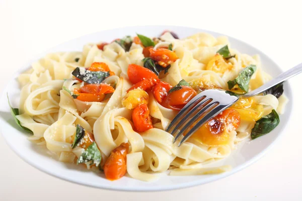 A plate of tagliatelle with grilled red and yellow cherry tomatoes — Stock Photo, Image