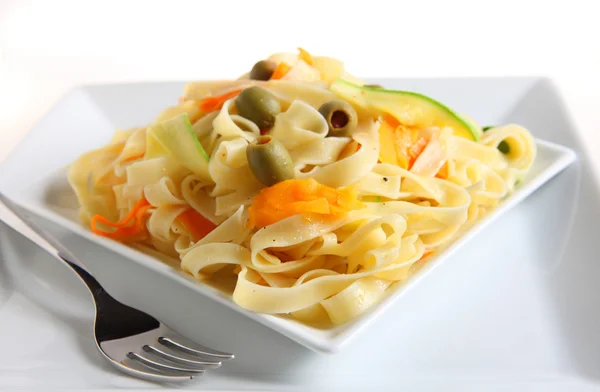 A plate of tagliatelle with ribbons of carrot and courgette — Stock Photo, Image