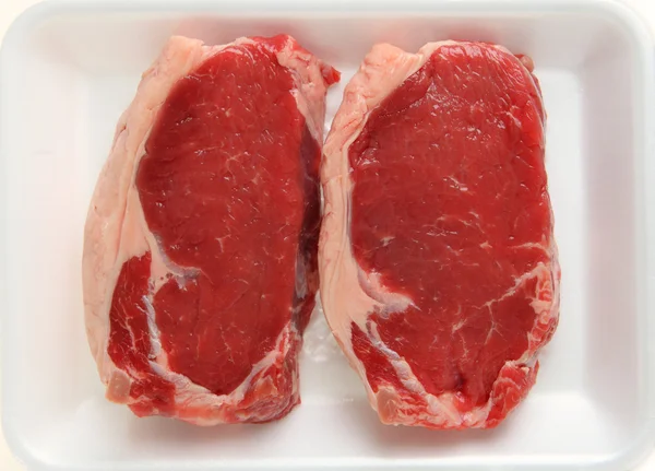 Twee rauwe kalfsvlees sirloin steak in een supermarkt slagers lade — Stockfoto