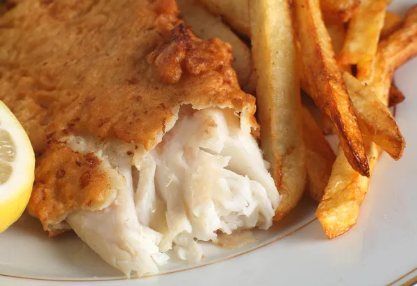Een stukje vis in beslag geserveerd met Frans gebakken aardappels, chips — Stockfoto