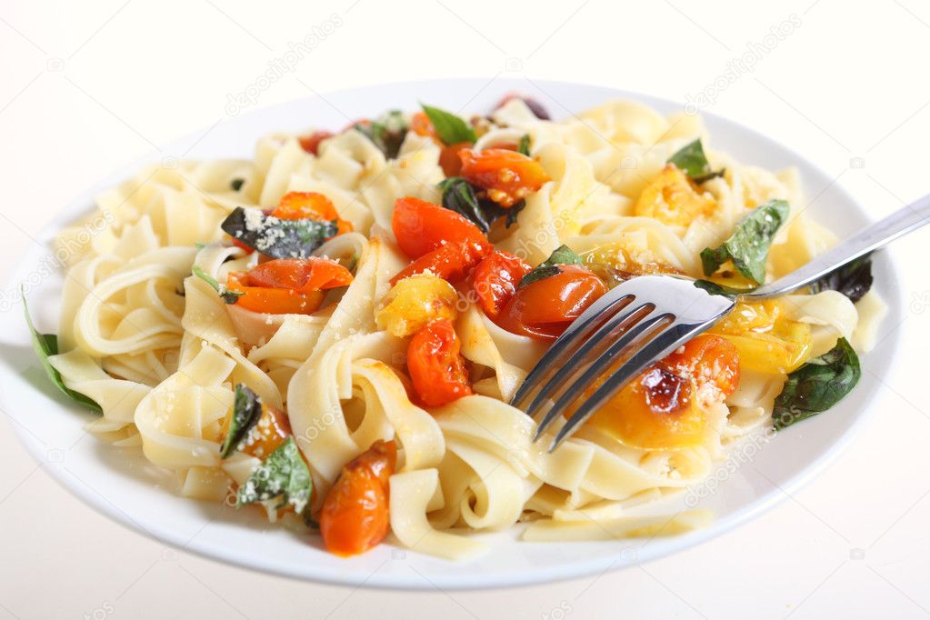A plate of tagliatelle with grilled red and yellow cherry tomatoes