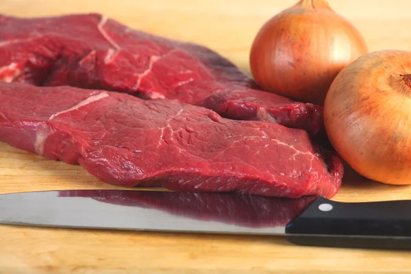 Raw steak and onions — Stock Photo, Image