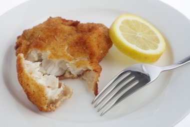 Breaded fish fillet with lemon and fork clipart