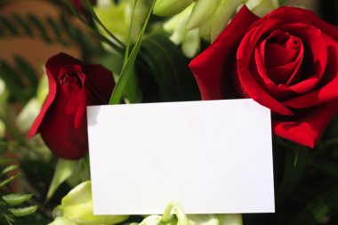 Red roses, orchids and a blank card clipart