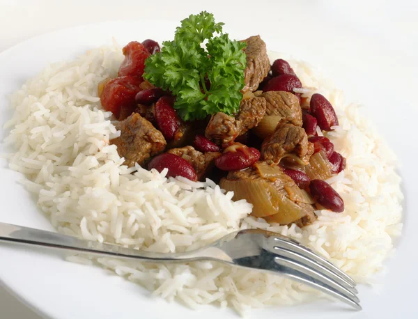 Plate of chili con carne with red beans topped with a sprig of basil — Stock Photo, Image