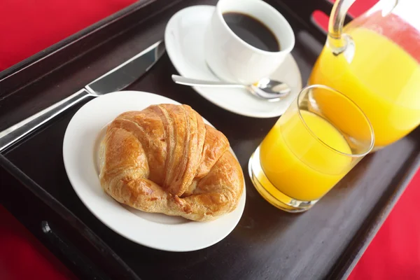 A kontinentális reggelit egy croissant-t fekete kávé és narancs leve — Stock Fotó
