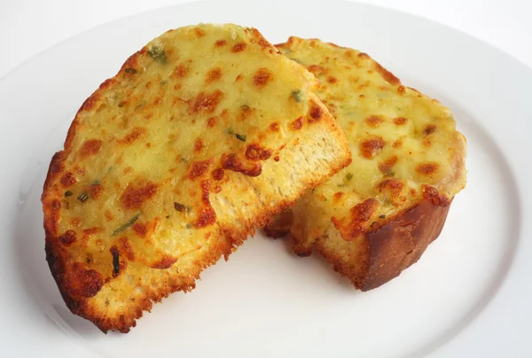 Two pieces of garlic bread topped with cheese on a white plate — Stock Photo, Image