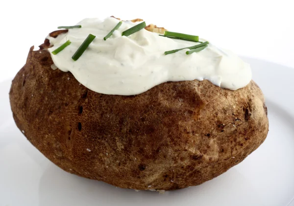 Eine gebackene Zwieback-Kartoffel, garniert mit Frischkäse und Schnittlauch — Stockfoto