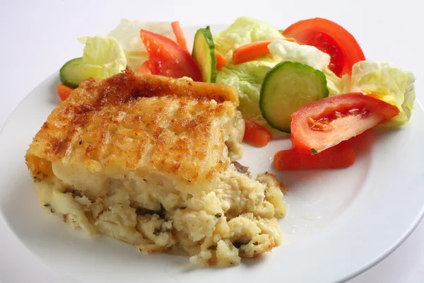 Английский рыбный пирог и салат — стоковое фото