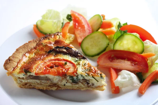 En paj med svamp, tomat och persilja serveras med en sallad. — Stockfoto