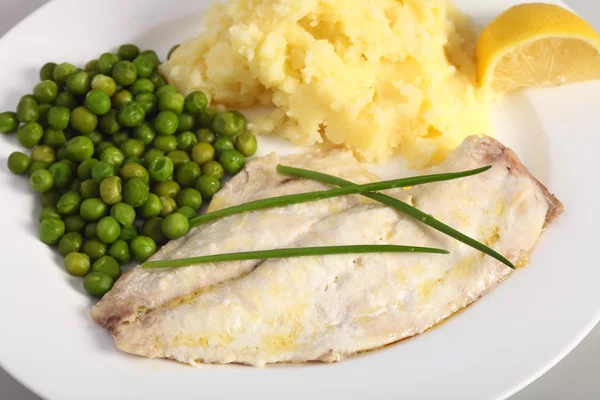 Печеная рыба, лимон и овощи — стоковое фото