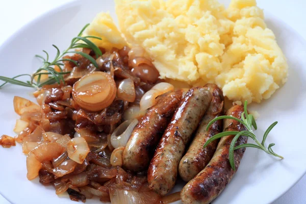 Sausages fried onions and potato — Stock Photo, Image