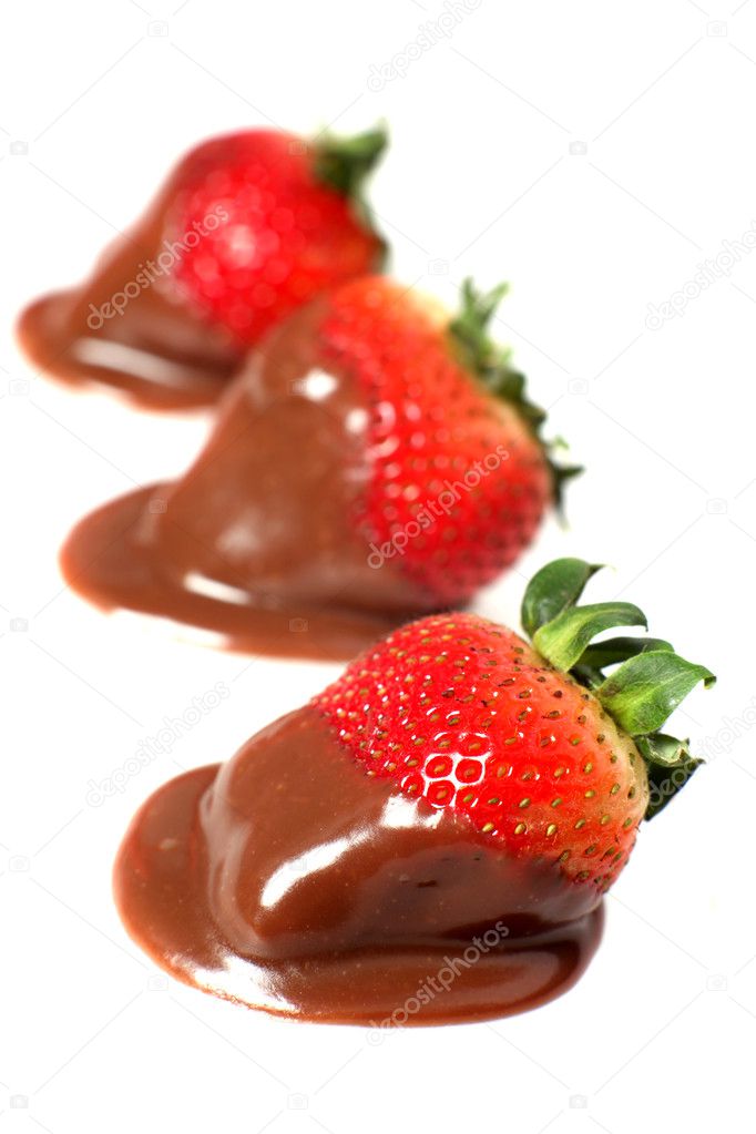 Chocolate sauce dipped strawberries in a row over white