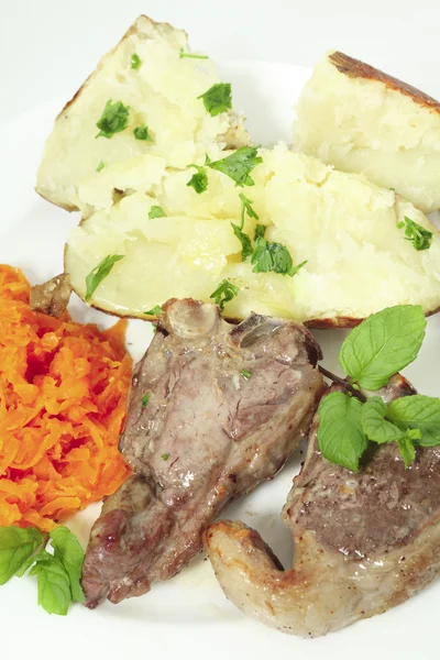 Lamskoteletten wortelen en gebakken aardappel verticale — Stockfoto