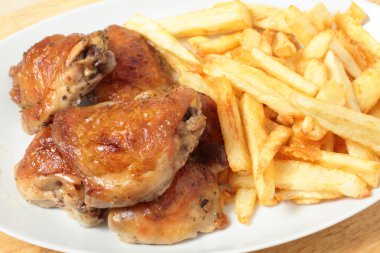 Roast chicken thighs and fries high angle clipart