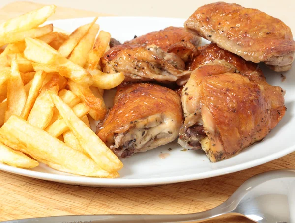 Roast chicken thighs and fries with spoon