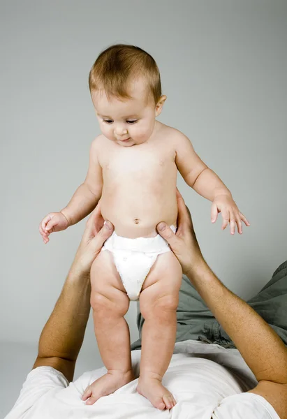 Bebé de pie sobre papá — Foto de Stock
