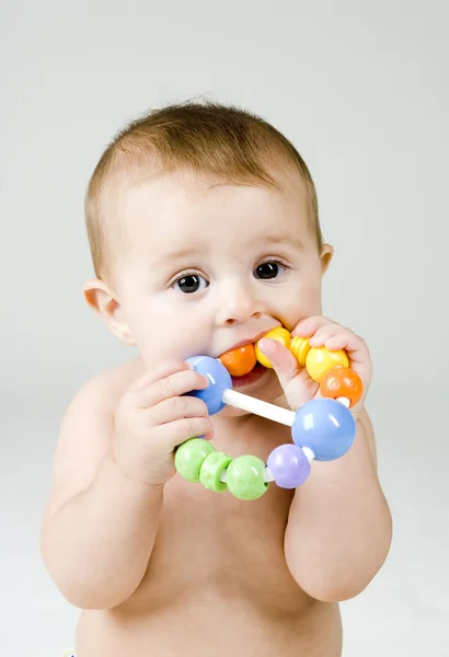 Baby kaut auf Spielzeug — Stockfoto