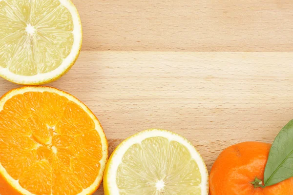 Citrus border on wooden table — Stock Photo, Image
