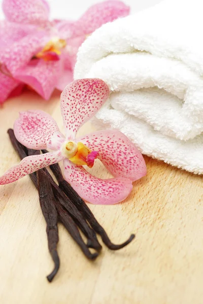 Judías de vainilla, toalla blanca y flor de orquídea —  Fotos de Stock