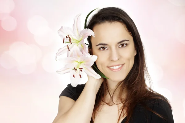 Beautiful young woman with lily flower — Stock Photo, Image
