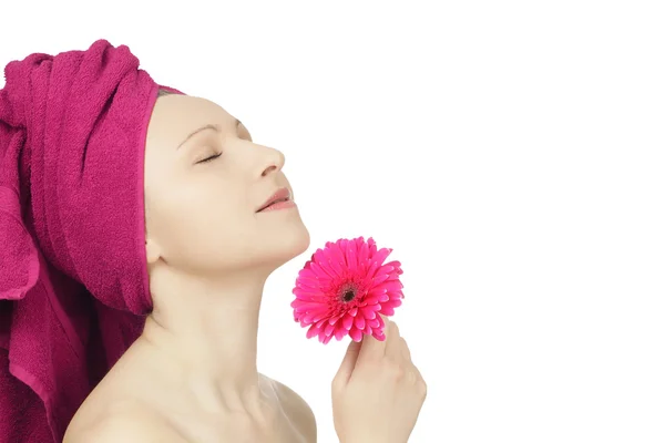 Giovane donna con asciugamano e fiore di gerbera — Foto Stock