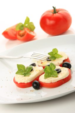 mozzarella ve fesleğen ile sunulan domates