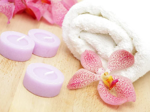 Handdoek met orchidee en kaarsen — Stockfoto