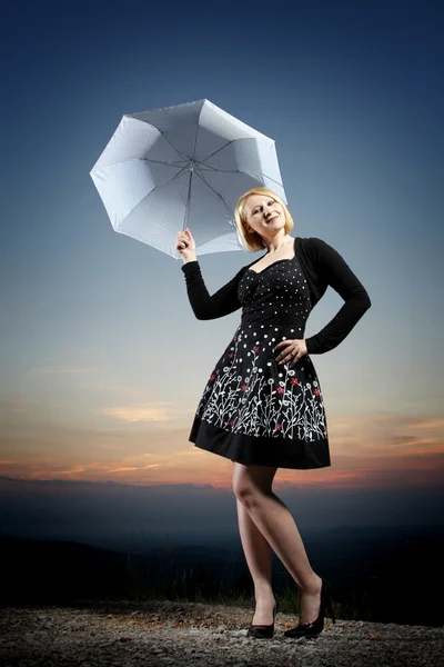Young blonde woman with umbrella — Stok fotoğraf