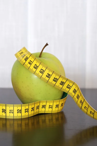 Измерительная лента и яблоко — стоковое фото