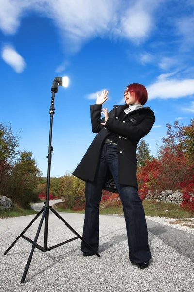 Suprised woman in front of flash light — Stock Photo, Image